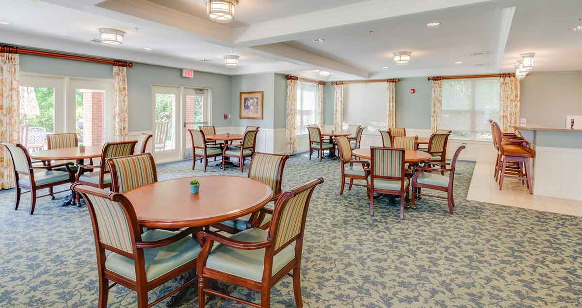 A dining room with tables and chairs at Victory Crest.
